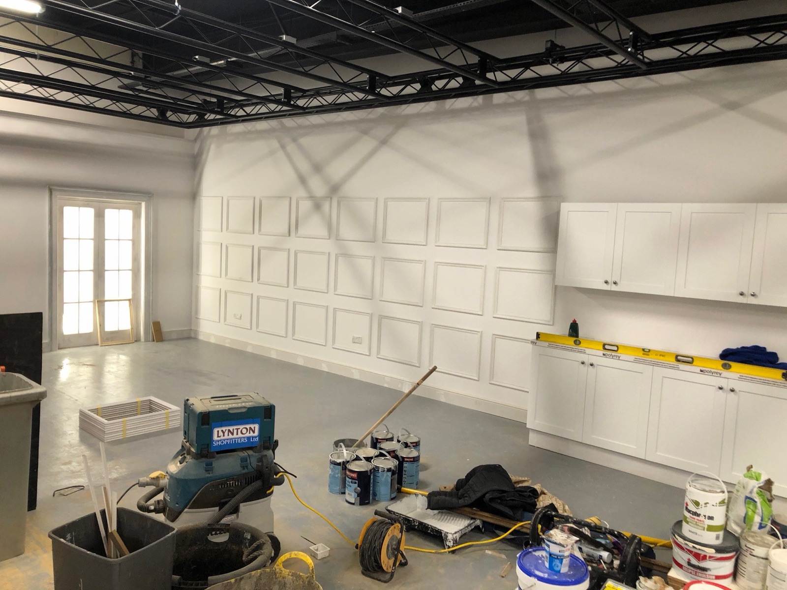 Olympian Decor team mid-way through a commercial fit-out, paint and equipment staged in a prepared room